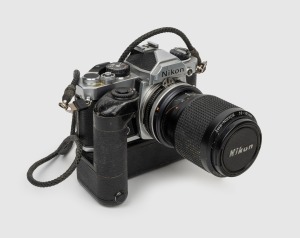 NIPPON KOGAKU: 1977 Nikon FM SLR camera with Nikon MD-11 motor drive and Zoom-Nikkor 35-105mm f3.5-4.5 lens (with cap).