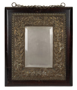 An antique bevelled mirror with floral repousse surround, mounted on timber panel, 19th century, ​​​​​​​44 x 37cm overall.