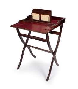 An antique English mahogany folding campaign desk with nickel plated fittings and scarlet leather interior, circa 1900, bearing ivorine plaque "BEST LONDON MAKE", 79cm high, 56cm wide, 58cm deep when open.