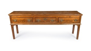 A Georgian provincial pine three-drawer dresser base with peg joint construction and brass handles, 18th century, 76cm high, 193cm wide, 44cm deep.