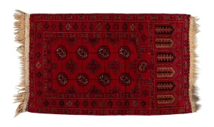 A hand-knotted wool prayer rug on red ground, 130 x 75cm.