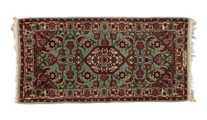 A Persian hand-knotted wool rug on sage green ground, 145 x 72cm.