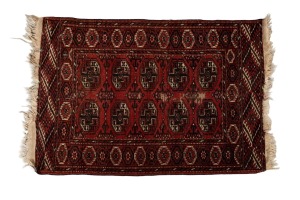 A hand-knotted wool rug on red ground, 130 x 88cm.