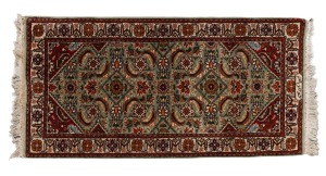 A Persian hand-knotted rug with floral motif on sage ground, ​​​​​​​145 x 71cm.