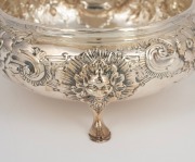 An antique English sterling silver bowl with floral repousse decoration resting on three pad feet with facemask adornments, by Charles Engelhard of London, circa 1881, 5.5cm high, 13cm wide, 166 grams. - 2