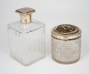 An Art Deco sterling silver lidded crystal bottle of square form, together with a cylindrical antique hobnail cut crystal jar with floral decorated sterling silver lid, 19th/20th century, (2 items), 14cm and 9cm high, the lids 56 grams total.