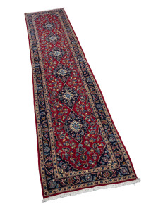 A Persian hand-knotted wool runner rug on red ground, 450 x 100cm.