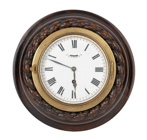 An antique bulkhead clock in brass case with timber rope surround, one piece enamel dial and lever escapement timepiece with Roman numerals, 19th century, 28cm diameter.