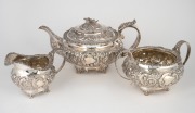 A Georgian three piece English sterling silver tea service with repousse floral decoration, stamped "G.H.", made in London, circa 1823, the tea pot 14cm high, 27cm wide, 1290 grams total.