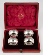 A set of four antique English sterling silver napkin rings housed in original scarlet leather plush fitted retailer's box, made in Sheffield, circa 1907, ​​​​​​​the box 14cm wide, 66 grams total.