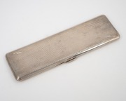 An antique sterling silver cigarette case with engine turned decoration and gilt wash finish to the interior, made in Birmingham, 20th century, elegant and unusually long form 17cm wide, 122 grams.