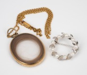 A 9ct gold chain (4.2 grams) with an antique gold plated memorial hair locket; together with a sterling silver and pearl brooch, (2 items).