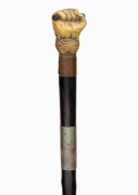 An antique poacher's walking stick with rosewood veneered shaft, finely carved whale's tooth fist grip and silver collar engraved "Load Me Well & Keep Me Clean, & When I Strike I Make A Scene" with owner's initials below "J.M.M.", 19th century, 86cm long.