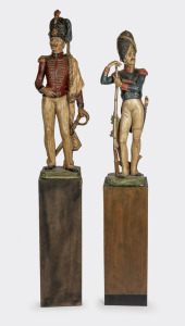 A pair of vintage fired plaster military statues with hand-painted finish, on later plinths, 20th century, ​​​​​​​the statues 98cm high, 170cm high overall.