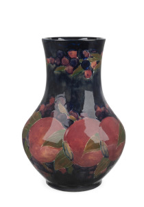MOORCROFT "Pomegranate" baluster shaped English pottery mantle vase on blue ground, underglazed green signature mark to base and additional impressed factory mark "Moorcroft, Burslem, England", 27cm high.