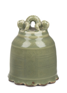 A Chinese celadon glazed porcelain ceremonial bell with figural top, Qing Dynasty, 18th/19th century, 10.5cm high, 8cm wide.