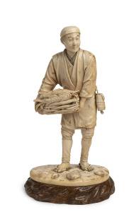 A fine quality antique Japanese okimono of a fish monger, on elm base, Meiji Period, 19th/20th century, red seal mark and cartouche to base, 24cm high overall including base.