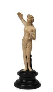 An antique Dieppe ivory statue of a female nude with grapes and goblet, standing on a turned ebony plinth, 19th century, 21cm high.