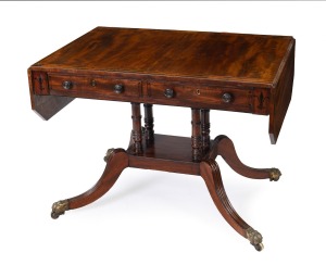An antique Regency mahogany sofa table, the cantered corner mahogany top crossbanded with rosewood, ebony and boxwood stringing, two drawers to the frieze, turned support base with quadraform splay legs terminating on brass lion paw castors, circa 1825, 7