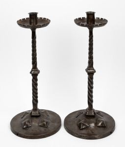 A pair of Arts and Crafts wrought iron candlesticks, 20th century, 48cm high.