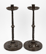 A pair of Arts and Crafts wrought iron candlesticks, 20th century, 48cm high.