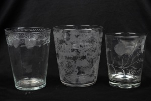 Three assorted antique oversized beakers with wheel engraved decoration, 19th century, the largest 14.5cm high, 12.5cm diameter.