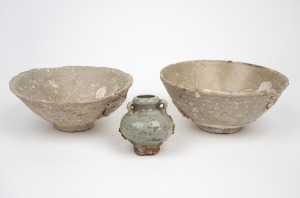 Two antique Chinese celadon shipwreck bowls; together with a celadon pot, Ming Dynasty, 16th/17th century, (3 items), the largest 8cm high, 17cm wide.