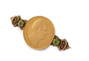 An 1835 English 22ct gold sovereign mounted as a brooch on a 9ct gold bar flanked by green stones, 19th century, 4.5cm wide, 12.8 grams total.