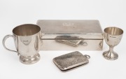 A sterling silver christening mug, eggcup, cigarette case and cigarette box (585 grams including cedar lining), 19th and 20th century, (4 items), 823 grams total including box with cedar lining.