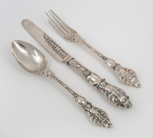 A three piece sterling silver christening cutlery set comprising of a knife, fork and spoon, all attractively decorated with putti figures, made in Sheffield, circa 1875, the knife 19.5cm long, 128 grams including filled knife handle.
