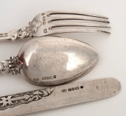 A three piece sterling silver christening cutlery set comprising of a knife, fork and spoon, all attractively decorated with putti figures, made in Sheffield, circa 1875, the knife 19.5cm long, 128 grams including filled knife handle. - 2