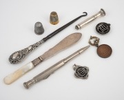 Sterling silver lace hook, pate knife and cigar punch, together with two metal thimbles, a vintage pen and three rowing fobs (one in sterling silver), 19th and 20th century, (9 items), ​​​​​​​the largest 17cm long.