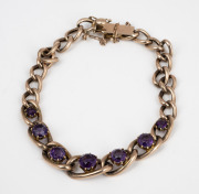 A 9ct rose gold graduated curb link bracelet, set with purple stones, early 20th century, stamped "9ct", ​​​​​​​11.7 grams total.