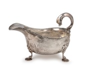 An antique Scottish sterling silver sauce boat with pad feet and dolphin handle, made by Hamilton & Inches of Edinburgh, circa 1910, ​​​​​​​11cm high, 16cm wide, 200 grams.