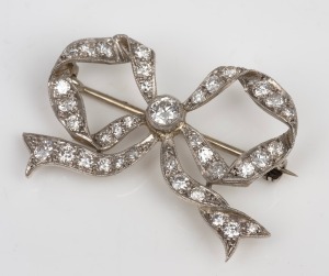 An antique white gold and diamond bow brooch, early 20th century, 3.5cm wide, 5 grams.