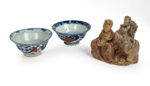 A Chinese carved soapstone figural group, early to mid 20th century; together with two antique Chinese tea bowls, 19th/18th century, (3 items), the figure 9cm high.