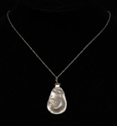 A sterling silver mounted pearl shell pendant on sterling silver chain, housed in a MIKIMOTO branded plush box, ​​​​​​ ​​​​​​​the pendant 3.5cm high, the chain 60cm long.