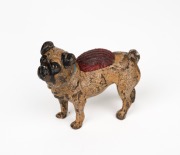 An antique Austrian cold painted bronze miniature pug dog pin cushion, circa 1900, 5cm high, 6cm long.