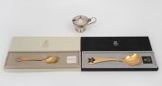 Two GEORG JENSEN Danish gilded silver and enamel spoons in original boxes, together with a sterling silver mustard pot (glass liner and base glued in), 20th century, (3 items), the spoons 70 grams total, the mustard pot 96 grams total including lining and