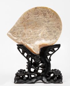 An antique Chinese carved pearl shell ornament on carved ebonized timber stand, Qing Dynasty, 19th century, 28cm high overall.