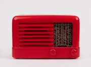 A vintage mantle radio in red finish, mid 20th century, ​​​​​​​18cm high.