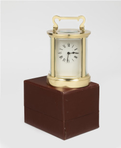 A French cylindrical cased carriage clock with convex glass panels, housed in original box of purchase, 20th century, 15cm including handle.