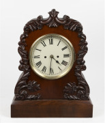 An antique English spring table clock, circa 1860. Mahogany scroll style case with applied floral carved decoration with circular painted cream dial with Roman numerals, spade hands and cast brass locking bezel. Two train eight day fusee movement with anc