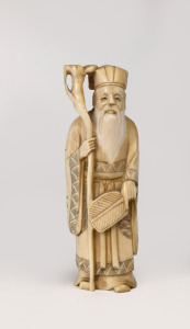 A Japanese carved ivory statue of a scholar holding a staff, Meiji period, 20th century, incised signature to base, 13cm high.