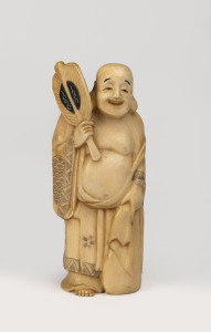 A Japanese carved ivory statue of a man with a fan, Meiji period, 20th century, incised signature to base, 10.5cm high.