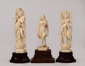 A carved Indian ivory statue of Mahatma Gandhi; together with two Indian carved ivory statues of Krishna, both mounted on timber bases, mid 20th century, (3 items), the largest 12cm high including base.