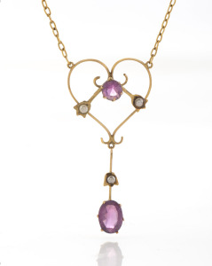 An antique 9ct gold negligee necklace with heart shaped pendant, set with purple stones and seed pearls, early 20th century, stamped "9c", the chain 40cm long, the pendant 5cm high, 3.8 grams total.