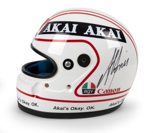 ALAN JONES' RACING HELMET: A race-worn helmet (Snell SA85), signed by Alan Jones, with AGV, AKAI, Canon, and Marlborough sponsorship decals, worn by Jones in an unspecified race, and accompanied by a copy of an email from him certifying this to be a "genuine helmet worn by me".