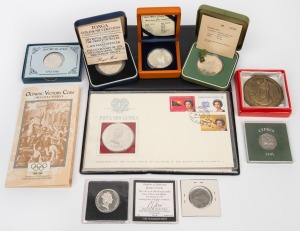 An eclectic group of world coins, mostly silver, including 1973 Germany two mark, 1980 Samoa $10, 1981 Tonga half hau, 1982 U.S. half-dollar, 1994 Cook Islands "James Cook" $10, 1996 Greece "Olympic Victory Coin", 2003 Mongolia 500 togrog, and others. (9 