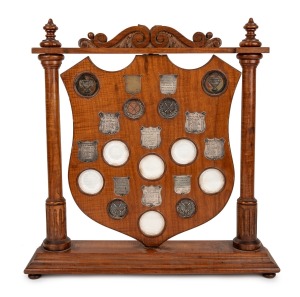 RONALD VANNECK POWELL (1884-1930): A fiddleback blackwood rotating shield display incorporating original plaques and medals (variously bronze and silver) from throughout Powell's rowing career, with distinctions present including "Henley Regatta - Visitors Challenge Cup", "Head Of The River - Universitas Cantabrigiensis", "1901 Eton House Fours" (also for 1903), and "1902 Eton Trial Eights" (also for 1903), and others; 49 x 48cm overall.
